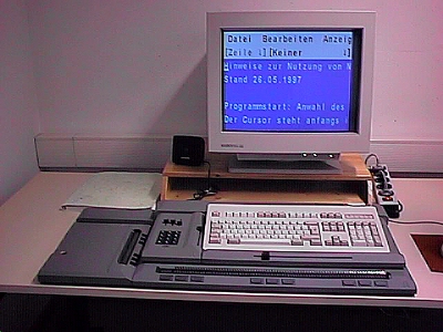 Computerarbeitsplatz mit Monitor, Lautsprechern, Tastatur und Braille-Zeile
